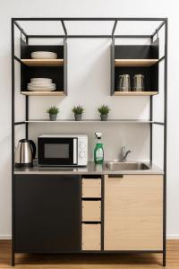 a kitchen with a microwave and a sink at Hotelkonkurrenz Hostel in Nuremberg +18 photos