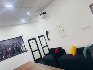 a living room with a couch and a bird on the wall at Black & White Elephant Lobby in Mahiyangana