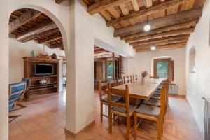 Sant Iscle de VallaltaにあるCan Rocosaの木製のテーブルと椅子のあるキッチンとダイニングルーム