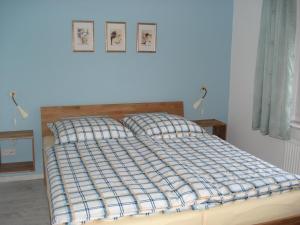 a bed with a blue and white plaid blanket on it at "CASA-MARE" Fehmarn in Wulfen auf Fehmarn