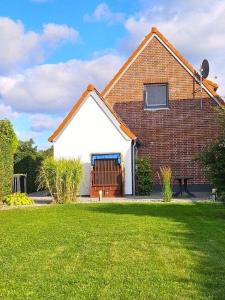 a brick house with a large lawn in front of it at "CASA-MARE" Fehmarn in Wulfen auf Fehmarn