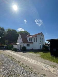 una casa bianca seduta su una strada sterrata di "Ruheoase" a Fehmarn