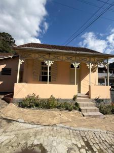 a house with a porch and stairs in front of it at Casarão Cidade Imperial in Petrópolis