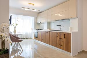 a kitchen with wooden cabinets and a sink and a table at 1001 Central Riverside Flat in Bucharest