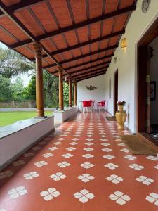 にあるPhalguni Farm Stayの赤い床に白い花が咲いたパティオ +20枚の写真