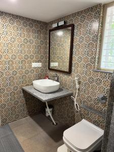 にあるPhalguni Farm Stayの洗面台とトイレ付きのバスルーム