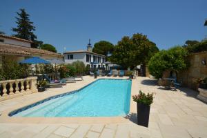 a swimming pool in a yard with chairs and a house at Les villas du Golf Mougins in Mougins