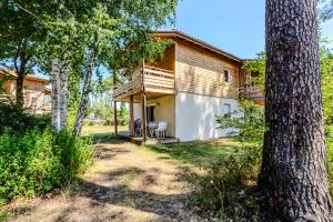 una capanna nel bosco con un albero di Appartement de type 2 cabine pour 4 personnes a Parentis-en-Born