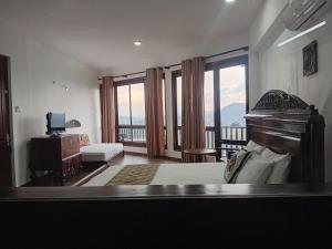 a bedroom with a bed and a balcony with a television at Lawan One Kandy in Kandy