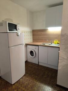 a kitchen with a white refrigerator and a washing machine at Appartement port Leucate in Leucate-Plage