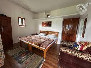 une chambre avec un lit et un canapé dans l'établissement Farmer's Homestay, Mukteshwar, à Mukteswar