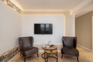 two chairs and a table in a room with a tv at Casa Branca 36 by An Island Apart in Funchal