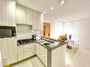 a kitchen with a sink and a counter top at Lindo Flat Garden beira-lago e perto da praia in Camaçari