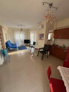 une cuisine et un salon avec une table et des chaises dans l'établissement Villa Dina, à Paralia Dionisiou