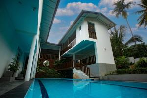 une maison avec piscine devant un immeuble dans l'établissement Royal Rich Villa, à Unawatuna
