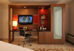 a bedroom with a desk and a television and a chair at Hotel Angeleno in Los Angeles