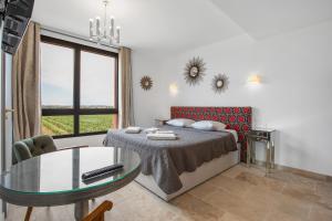 a bedroom with a bed and a glass table at Château Hermitage de Combas in Servian