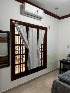 a room with a window with a white curtain at El Aljibe in Resistencia