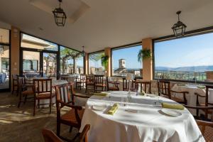 a restaurant with tables and chairs and large windows at Giotto Hotel & Spa in Assisi