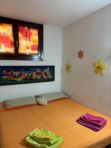 a room with a bed with two towels on it at Appartamento accogliente in Siniscola