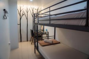 Habitación con litera y escritorio. en Nature Home Hostel & Cafe, en Chiang Mai