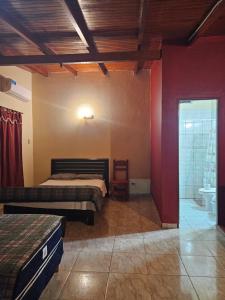 a bedroom with two beds and a bathroom at peixes apart in Puerto Iguazú