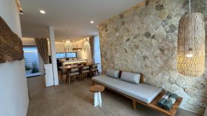 a living room with a couch and a stone wall at Dreamland View Villa #3 with Pool in Uluwatu