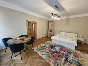 a bedroom with a bed and a table and chairs at Honterus Apartments I by Kronstay in Braşov