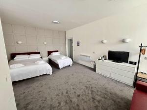 a bedroom with two beds and a flat screen tv at Abbotshall in Fife