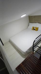 a large white bed in a room with a bench at Suíte 05 - Praia de Pajuçara - Castelo da Lolla in Maceió