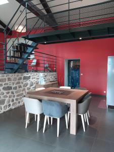 a dining room with a wooden table and chairs at La clé des Champs in Roche