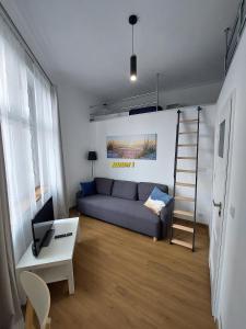 ein Wohnzimmer mit einem Sofa und einer Leiter in der Unterkunft Old Town Stage The Studio Suite Quartet in Krakau