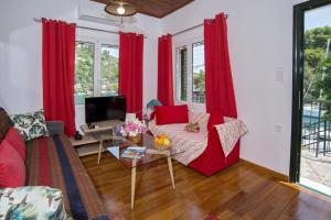 a living room with red curtains and a couch at Alma Libre in Gaios