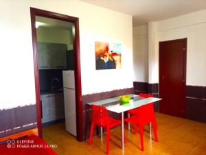 チェファルにあるStanza con bagno e cucina in comune in Villa Giardino Spiaggiaのキッチン(テーブル、赤い椅子2脚付)