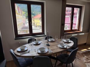 a table in a room with chairs and a large window at Alpin Apartments am Dorfbrunnen FAMILY SUITE in Steinach am Brenner