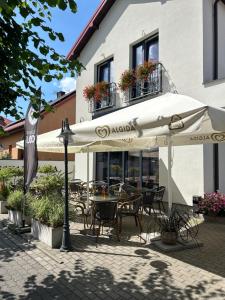 a patio with tables and chairs under an umbrella at Dworska 24 in Ciechanowiec