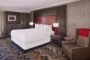 a bedroom with a large white bed and a chair at Horseshoe Tunica Hotel & Casino - A Caesars Rewards Destination in Tunica Resorts +46 photos