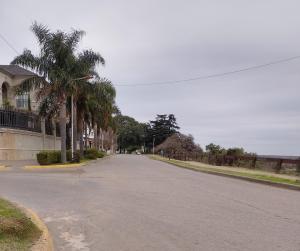 an empty street with palm trees and a house at Las Vellon in San Pedro