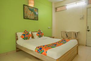 a bedroom with a bed in a green room at FabHotel Saraswati Niwas in Pune