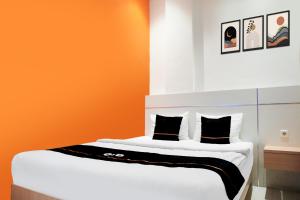 Postel nebo postele na pokoji v ubytování Townhouse Oak Palembang near Palembang Golf Club formerly KR Hotel