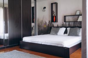 a bedroom with a large bed with white sheets at Casa cu Palmieri in Călimăneşti