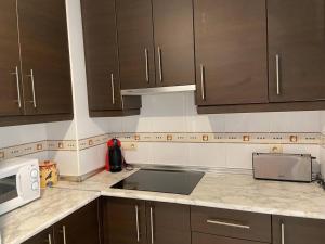 een keuken met bruine kasten en een aanrecht bij Brisamarina Playa Apartamento in Roquetas de Mar