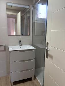een witte badkamer met een wastafel en een douche bij Brisamarina Playa Apartamento in Roquetas de Mar +15 foto's