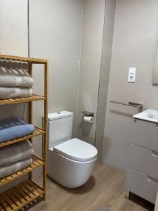 een badkamer met een toilet, een wastafel en handdoeken bij Brisamarina Playa Apartamento in Roquetas de Mar