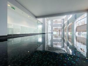 a swimming pool with a reflection of a building at Elegant 1BR Condo - Ultra Fast WiFi - BTS On-Nut in Bangkok