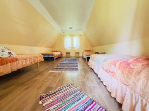 a attic room with two beds and a rug at Roosi Camping Houses in Rannaküla