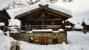 a log cabin with snow on top of it at Lechnerhütte Fane Alm in Valles