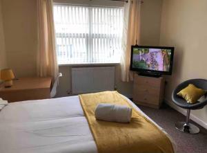 a bedroom with a large bed and a television at 34 - Room 3 - Uplands in Swansea