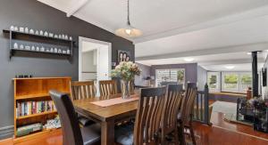 a dining room with a wooden table and chairs at Kedumba Cottage: Gorgeous Home 2 Min Walk to Town in Katoomba +27 photos