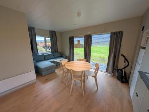 a living room with a table and chairs and a couch at Bragdavellir Cottages in Djúpivogur